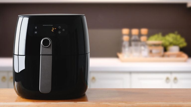 A black colored air fryer in the kitchen, How To Use A Philips Air Fryer [Step By Step Guide] - 1600x900