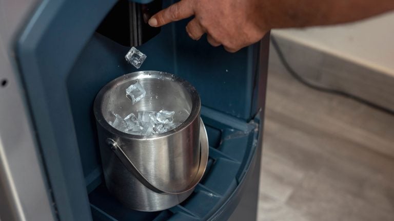 Pouring ice from the ice machine, How To Reset Sanitize Light On A Scotsman Ice Machine [Quickly & Easily] - 1600x900