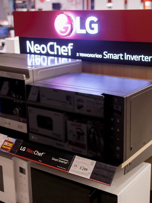 LG microwave ovens stand on a stand in a retail store